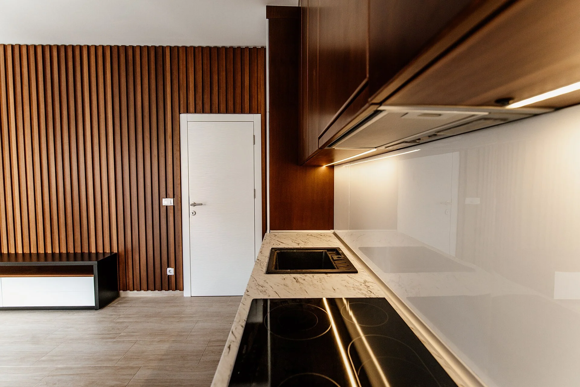 Cucina con mobile in legno, piano in marmo e porta bianca